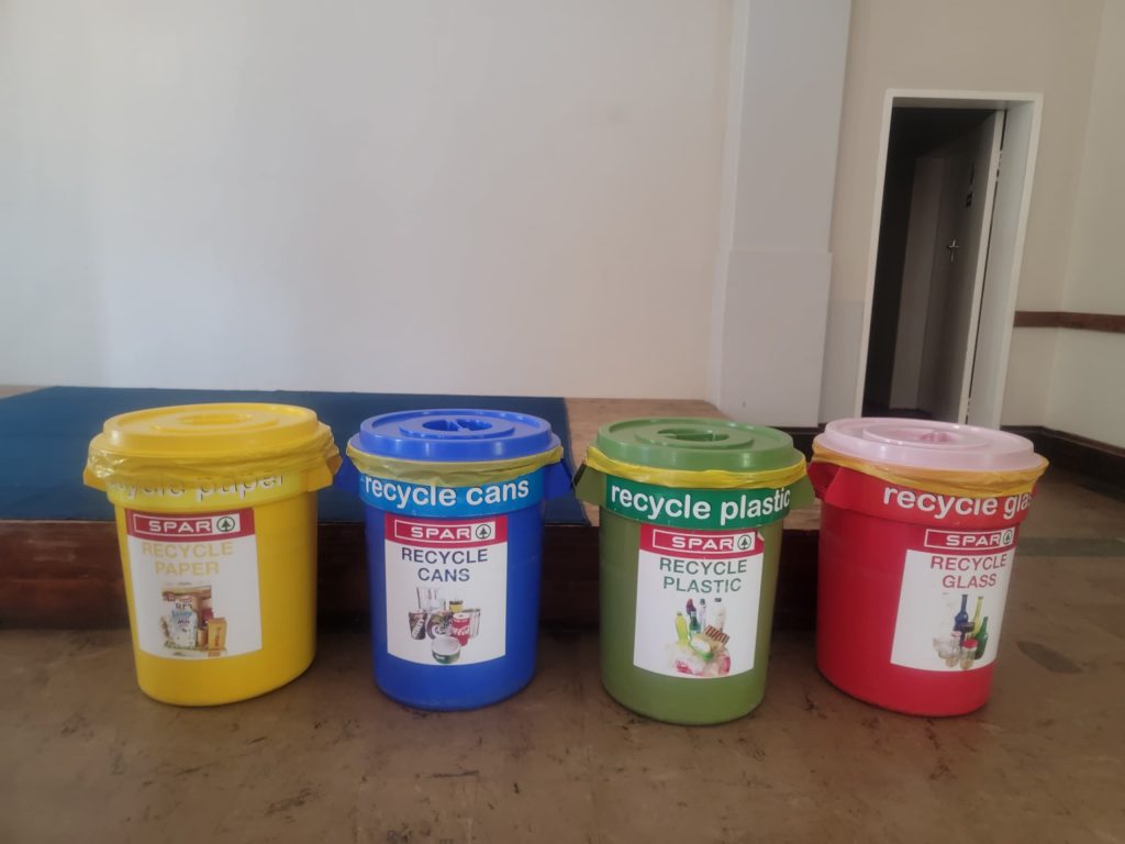 yellow bin for paper, blue bin for cans, green bin for plastic and red bin for glass